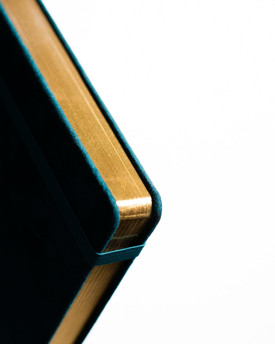 Close-up of a corner of a book with gold binding on a white background